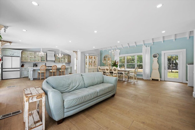 living room with visible vents, recessed lighting, and light wood-style flooring