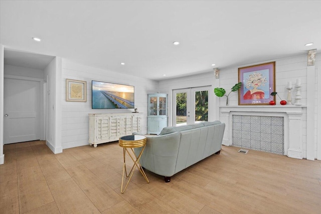 living area featuring recessed lighting, visible vents, french doors, and light wood finished floors