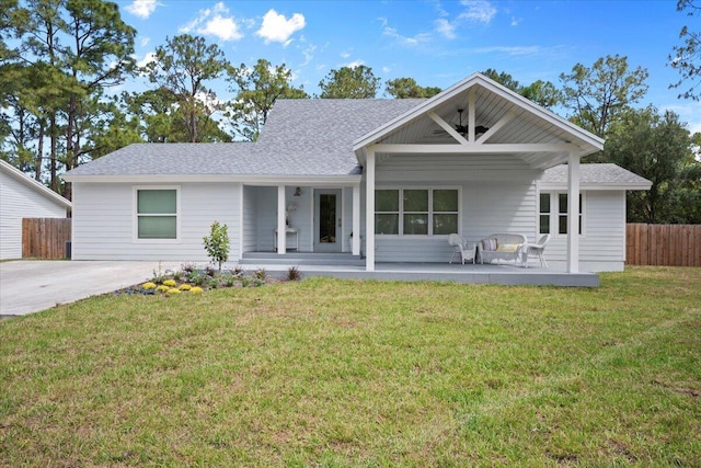 single story home featuring a front lawn, roof with shingles, fence, and covered porch
