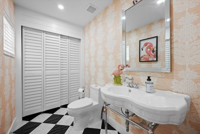 half bath featuring toilet, wallpapered walls, visible vents, and tile patterned floors