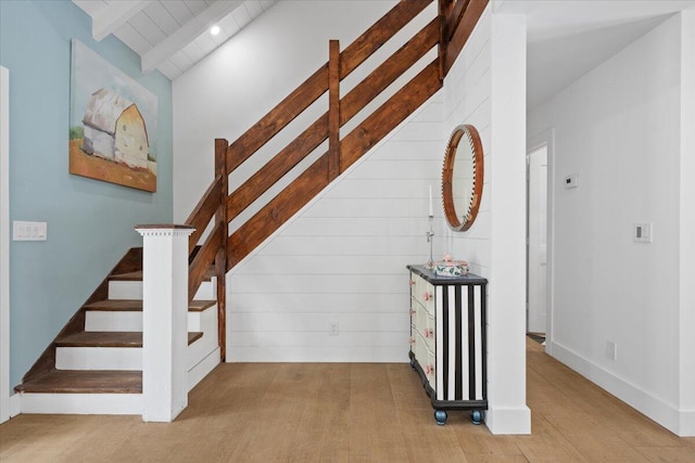 stairway featuring lofted ceiling with beams