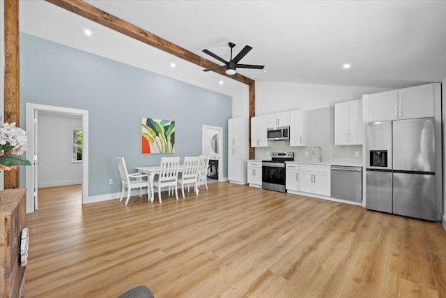 kitchen with high vaulted ceiling, light countertops, white cabinets, a ceiling fan, and stainless steel appliances