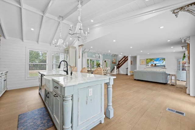 kitchen with visible vents, an inviting chandelier, vaulted ceiling with beams, light wood-type flooring, and a sink