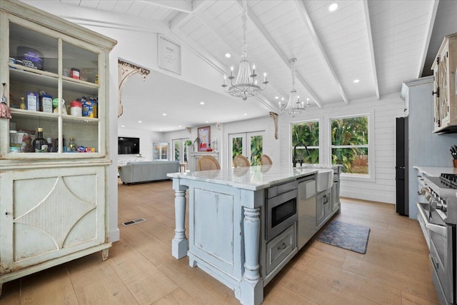 kitchen featuring visible vents, stainless steel appliances, light wood finished floors, and a notable chandelier