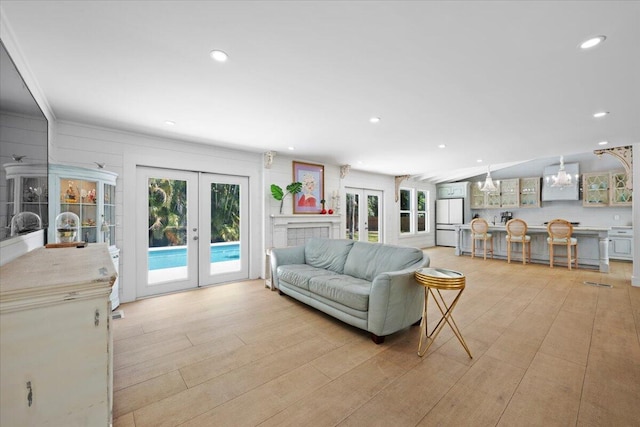 living room with recessed lighting, french doors, and light wood-style floors