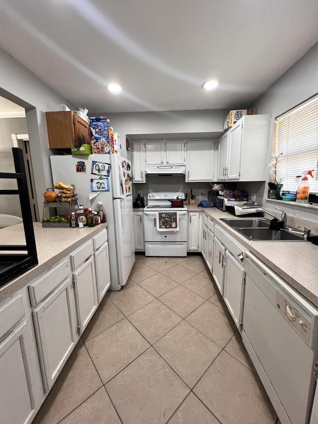 kitchen featuring white appliances, light tile patterned floors, under cabinet range hood, light countertops, and a sink