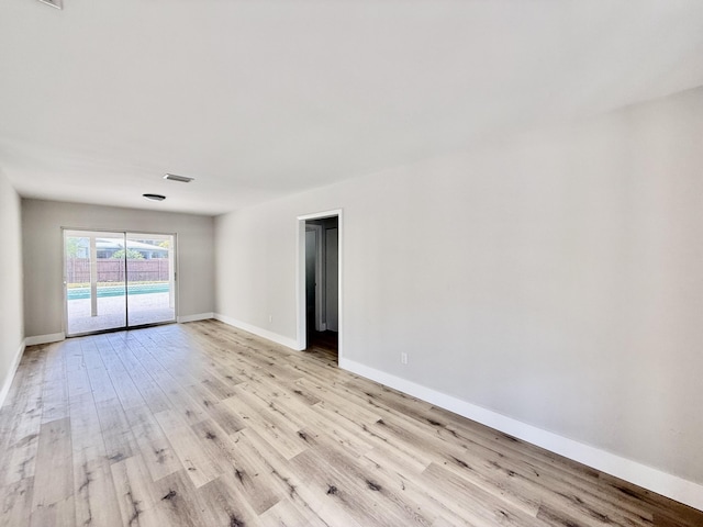 unfurnished room featuring baseboards, visible vents, and light wood-type flooring