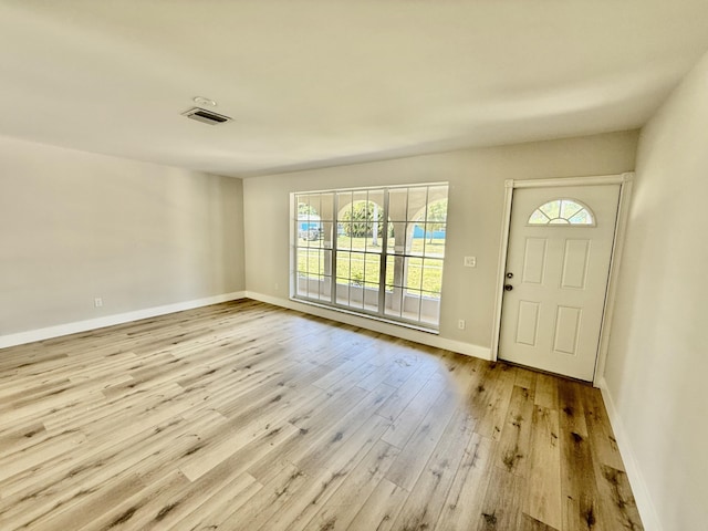 foyer with visible vents, baseboards, wood finished floors, and a healthy amount of sunlight