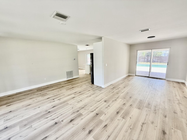 unfurnished room with baseboards, visible vents, and light wood finished floors