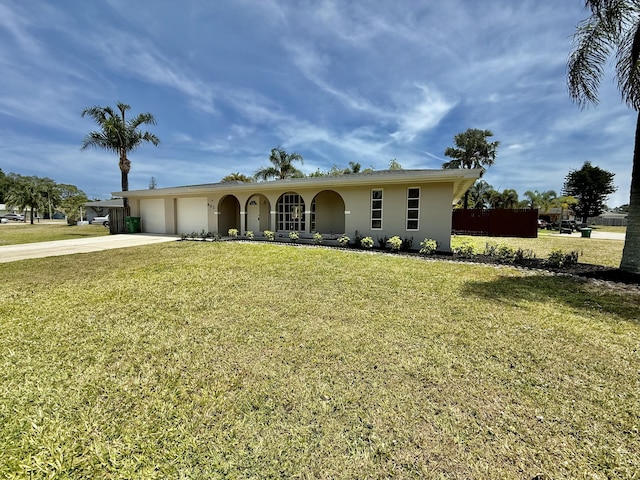 ranch-style house with a garage, stucco siding, driveway, and a front lawn