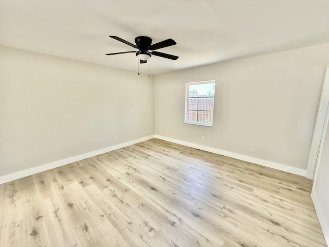 spare room featuring baseboards, a ceiling fan, and wood finished floors