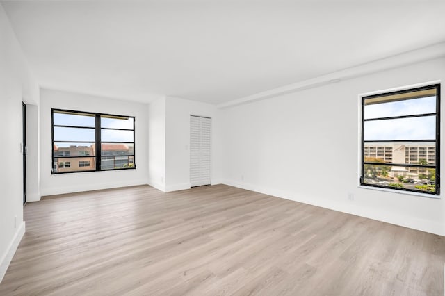 spare room with light wood-type flooring and baseboards