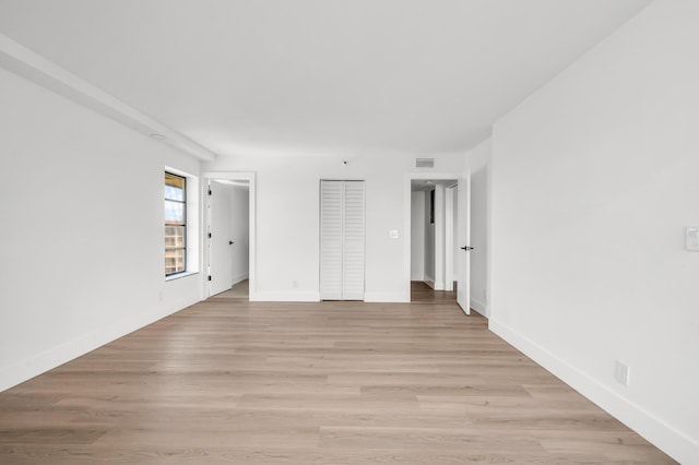unfurnished bedroom featuring visible vents, light wood finished floors, and baseboards