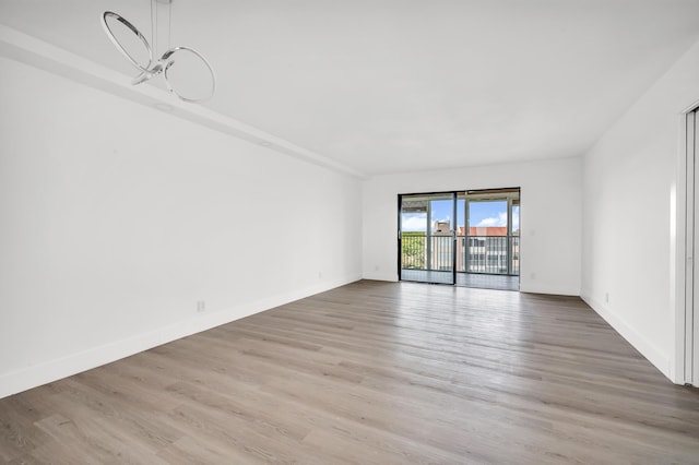 unfurnished room featuring baseboards and light wood finished floors
