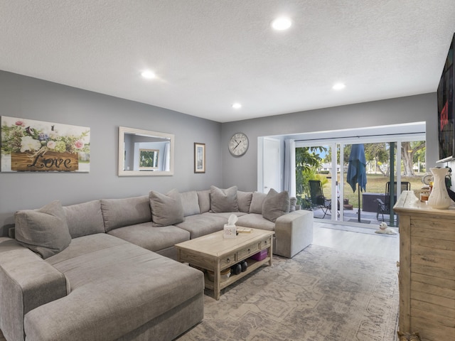 living room with recessed lighting, a textured ceiling, and wood finished floors