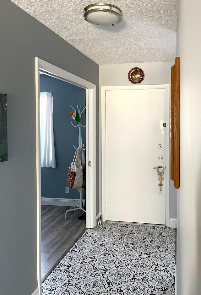 interior space featuring baseboards and a textured ceiling