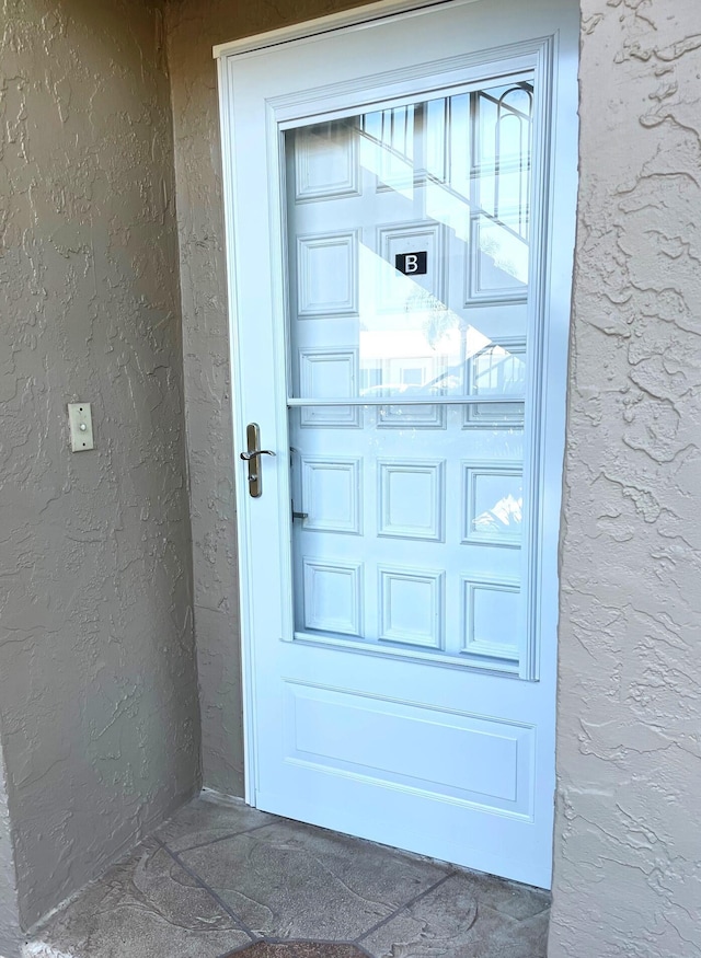 doorway to property featuring stucco siding