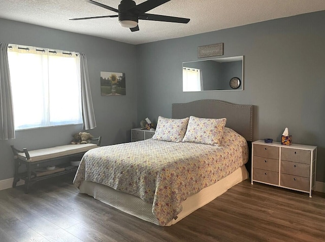 bedroom featuring a textured ceiling, baseboards, dark wood-style floors, and a ceiling fan