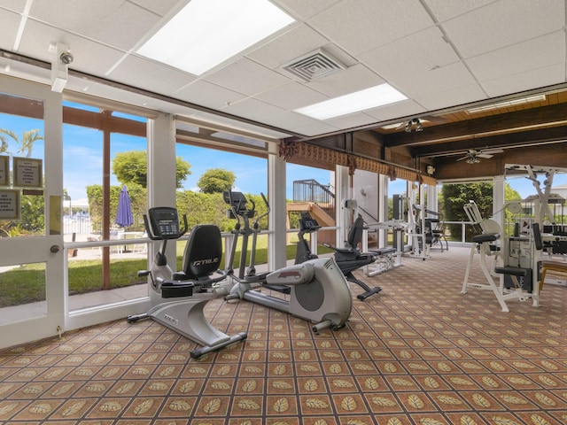 gym with carpet flooring, ceiling fan, visible vents, and a wall of windows