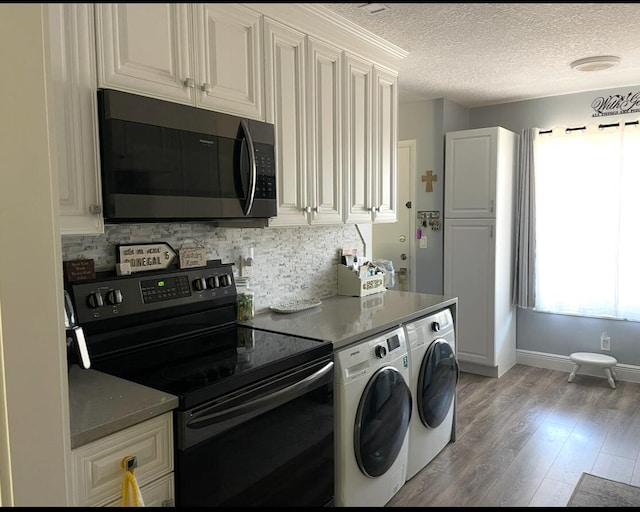 laundry area with laundry area, light wood-style floors, baseboards, a textured ceiling, and independent washer and dryer