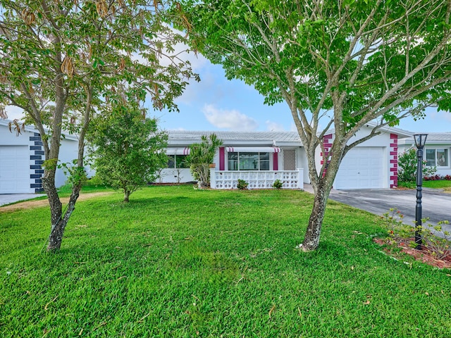 view of front facade featuring an attached garage, driveway, and a front yard