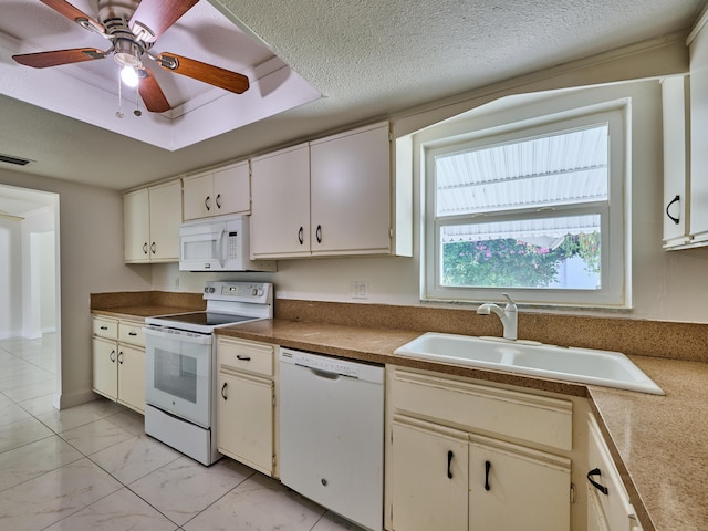kitchen featuring ceiling fan, visible vents, a sink, a raised ceiling, and white appliances