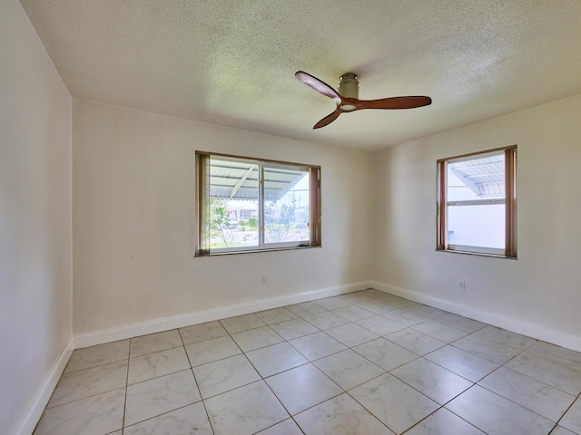 unfurnished room featuring light tile patterned floors, baseboards, ceiling fan, and a textured ceiling
