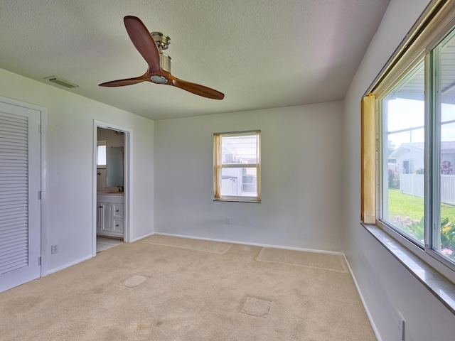 unfurnished bedroom featuring visible vents, multiple windows, and light colored carpet