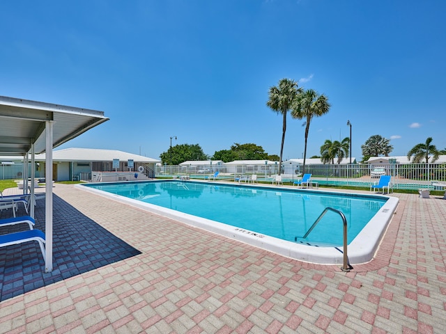 community pool with a patio and fence