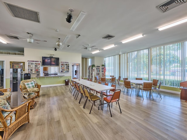 dining room with plenty of natural light, a ceiling fan, wood finished floors, and visible vents