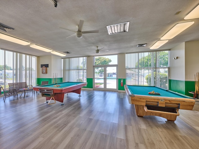 playroom featuring a textured ceiling, pool table, and a healthy amount of sunlight