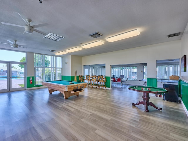 rec room with pool table, a textured ceiling, wood finished floors, and visible vents