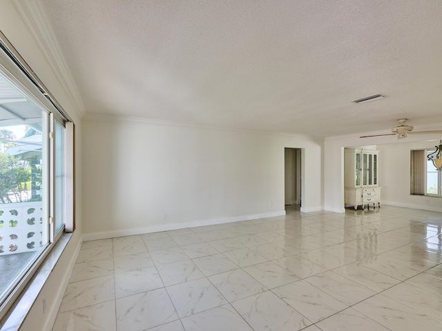 empty room featuring visible vents, marble finish floor, a textured ceiling, and crown molding