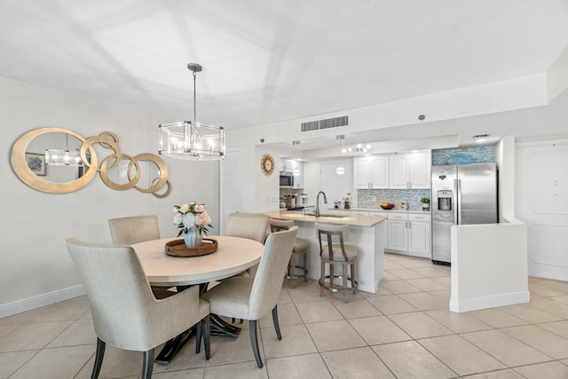 dining space with light tile patterned floors, visible vents, baseboards, and a notable chandelier