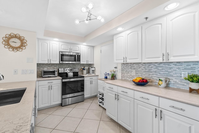 kitchen featuring a sink, stainless steel appliances, tasteful backsplash, a toaster, and light tile patterned floors