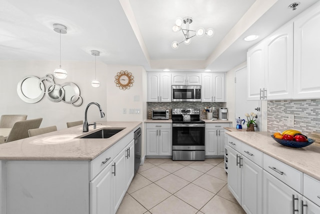 kitchen with light tile patterned floors, a sink, white cabinetry, stainless steel appliances, and tasteful backsplash