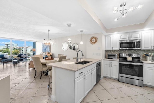 kitchen featuring an inviting chandelier, light tile patterned floors, stainless steel appliances, and a sink