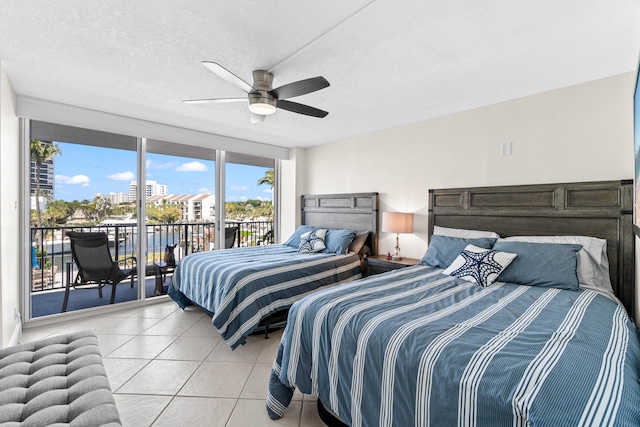 bedroom with ceiling fan, light tile patterned flooring, a textured ceiling, and access to exterior
