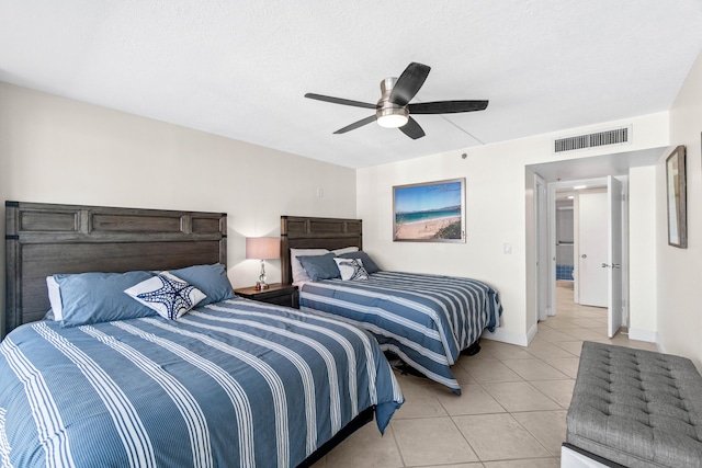 bedroom with ceiling fan, light tile patterned flooring, baseboards, and visible vents