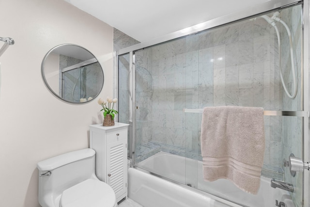 bathroom featuring toilet and combined bath / shower with glass door