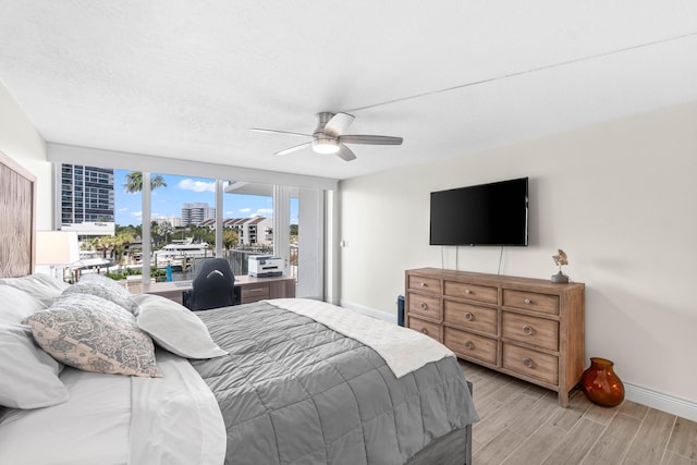 bedroom with baseboards, light wood-style flooring, and ceiling fan