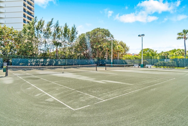 view of tennis court with fence and community basketball court
