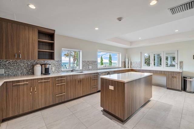 kitchen featuring decorative backsplash, visible vents, a healthy amount of sunlight, and a sink