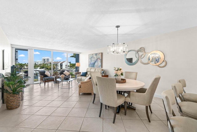 dining space with light tile patterned floors, a textured ceiling, a chandelier, and floor to ceiling windows
