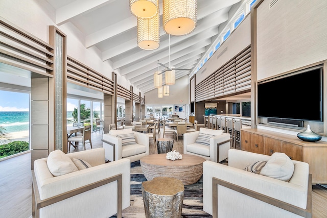 living area with wood finished floors, high vaulted ceiling, and beam ceiling