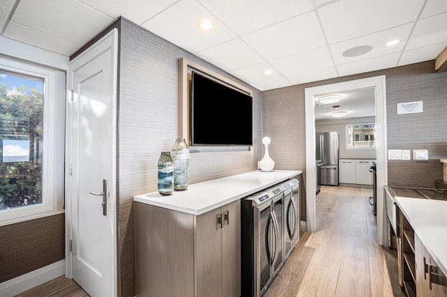 kitchen with freestanding refrigerator, light wood-type flooring, plenty of natural light, and beverage cooler