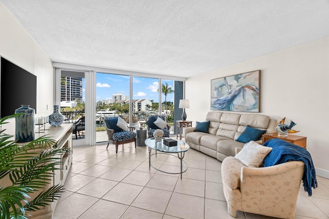 living area with floor to ceiling windows, light tile patterned floors, and a textured ceiling