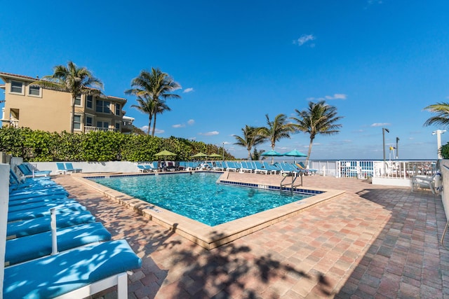pool with a patio and fence