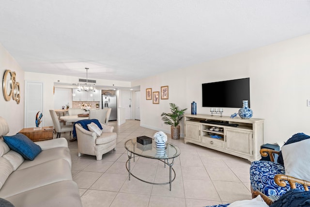 living area featuring light tile patterned floors, baseboards, a chandelier, and visible vents