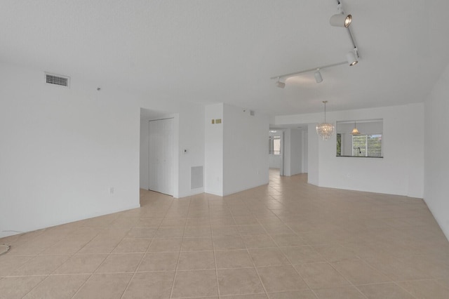 5874 Crystal Shores Dr Unit 308, Boynton Beach, FL 33437 - empty room with light tile patterned floors, track lighting, and a chandelier